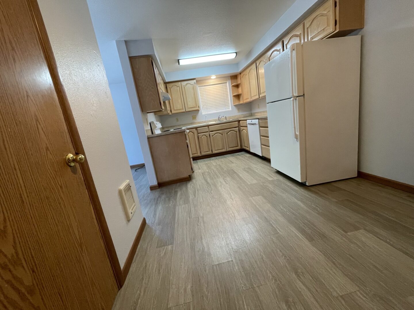 Modern kitchen with wooden cabinetry and light flooring.