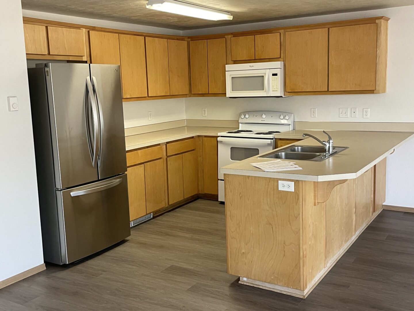 Modern kitchen with wooden cabinets and stainless steel appliances.